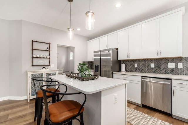 7306 Whimbrel Ln, Sunbury, OH 43074 - kitchen featuring appliances with stainless steel finishes, decorative backsplash, a kitchen island, white cabinets, and recessed lighting