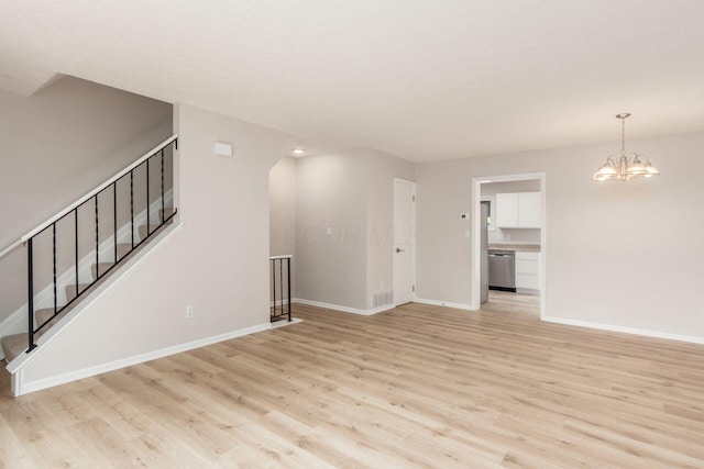 2353 Mccauley Ct Unit 6, Columbus, OH 43220 - unfurnished living room featuring light wood finished floors, baseboards, stairway, and a chandelier