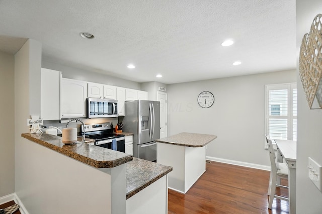 5932 Winberry Creek Dr Unit 1106, Dublin, OH 43016 - kitchen featuring appliances with stainless steel finishes, a kitchen island, dark wood-style floors, recessed lighting, and baseboards