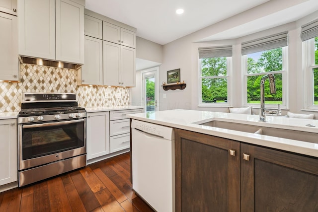 2407 Bryton Dr, Powell, OH 43065 - kitchen with stainless steel range with gas stovetop, white dishwasher, light countertops, a sink, and dark wood finished floors