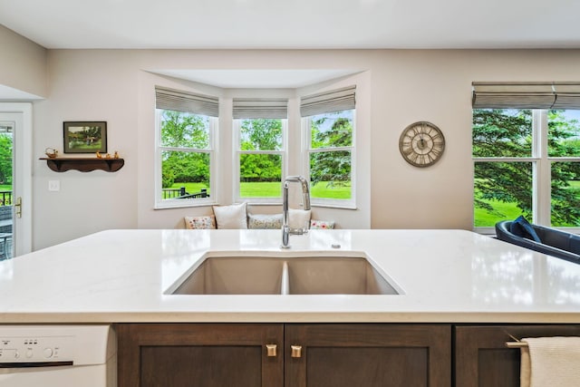 2407 Bryton Dr, Powell, OH 43065 - kitchen featuring a sink, light countertops, dark brown cabinets, and plenty of natural light