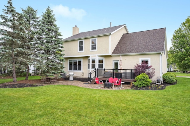 2407 Bryton Dr, Powell, OH 43065 - rear view of property featuring a shingled roof, a lawn, a chimney, stucco siding, and a deck