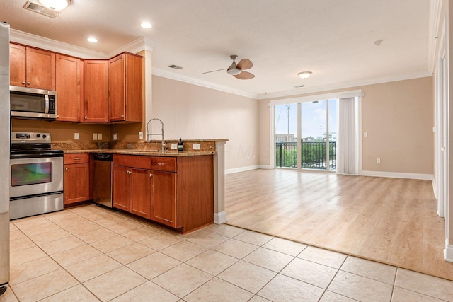 539 W 1st Ave Unit 308, Columbus, OH 43215 - kitchen featuring appliances with stainless steel finishes, a sink, crown molding, brown cabinetry, and ceiling fan