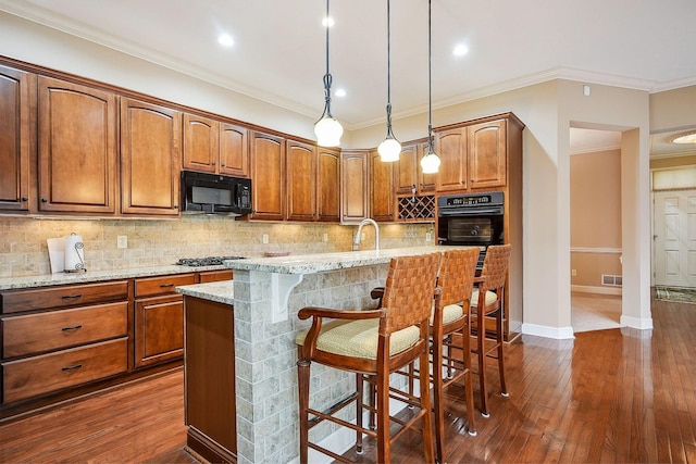 6711 Cooperstone Dr, Dublin, OH 43017 - kitchen with black appliances, a breakfast bar area, light stone counters, backsplash, and ornamental molding