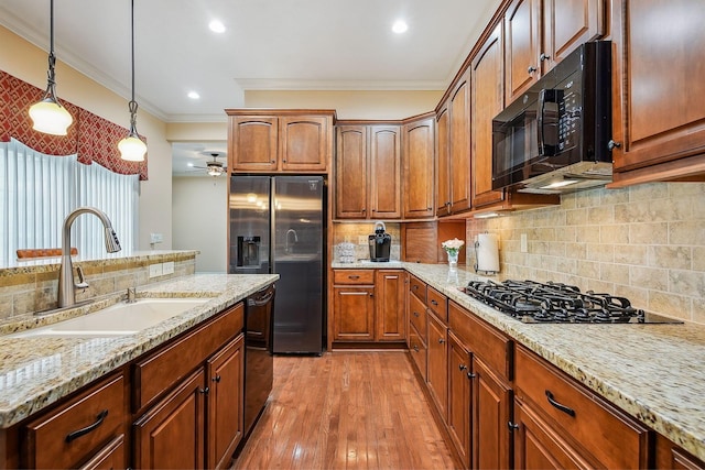 6711 Cooperstone Dr, Dublin, OH 43017 - kitchen featuring black appliances, a sink, crown molding, decorative light fixtures, and light stone counters