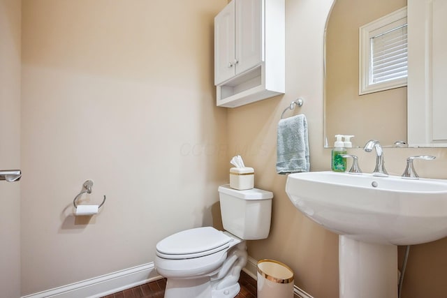 6711 Cooperstone Dr, Dublin, OH 43017 - half bath featuring baseboards, toilet, wood finished floors, and a sink