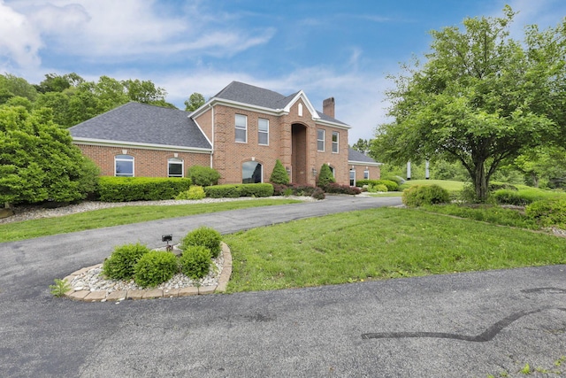2300 Stonewall Cemetery Rd SW, Lancaster, OH 43130 - georgian-style home with brick siding, a chimney, a front yard, asphalt driveway, and a shingled roof