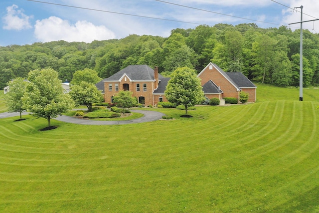 2300 Stonewall Cemetery Rd SW, Lancaster, OH 43130 - view of front of house with a front yard, brick siding, a wooded view, and a chimney