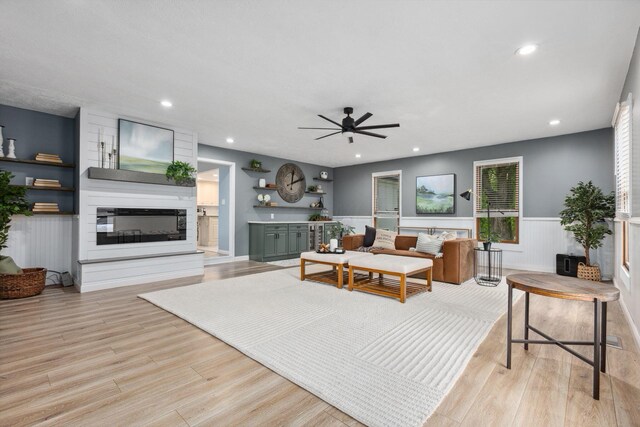 5210 Chevy Chase Ct, Columbus, OH 43220 - living room featuring a ceiling fan, light wood-style floors, a glass covered fireplace, wainscoting, and recessed lighting