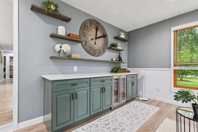 5210 Chevy Chase Ct, Columbus, OH 43220 - indoor dry bar with wine cooler, a wainscoted wall, light wood-style floors, a textured ceiling, and baseboards