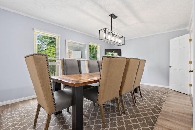 5210 Chevy Chase Ct, Columbus, OH 43220 - dining area featuring wood finished floors, crown molding, baseboards, a textured ceiling, and a chandelier