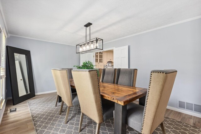 5210 Chevy Chase Ct, Columbus, OH 43220 - dining area with light wood-type flooring, a chandelier, crown molding, and baseboards