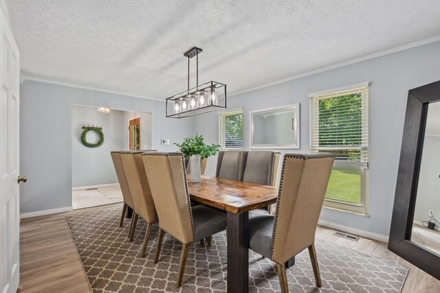 5210 Chevy Chase Ct, Columbus, OH 43220 - dining room with healthy amount of natural light, wood finished floors, crown molding, a chandelier, and a textured ceiling