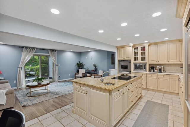 5210 Chevy Chase Ct, Columbus, OH 43220 - kitchen featuring stainless steel appliances, open floor plan, a sink, cream cabinetry, and light tile patterned flooring