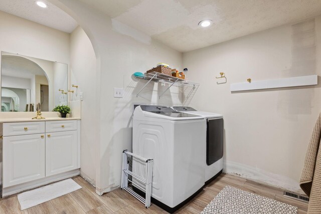5210 Chevy Chase Ct, Columbus, OH 43220 - laundry area with independent washer and dryer, light wood-type flooring, arched walkways, recessed lighting, and baseboards