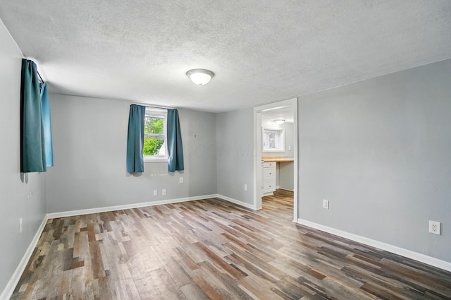 8301 Bennington Chapel Rd, Centerburg, OH 43011 - spare room featuring wood finished floors, a textured ceiling, and baseboards