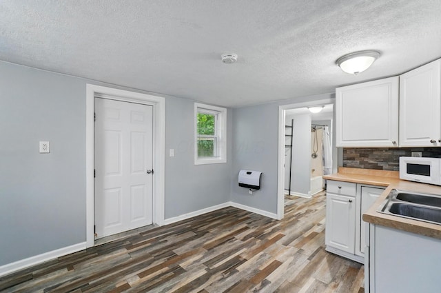 8301 Bennington Chapel Rd, Centerburg, OH 43011 - kitchen featuring a textured ceiling, white microwave, dark wood-style floors, white cabinets, and heating unit
