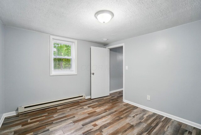 8301 Bennington Chapel Rd, Centerburg, OH 43011 - unfurnished room with baseboard heating, wood finished floors, a textured ceiling, and baseboards