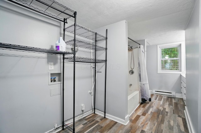 8301 Bennington Chapel Rd, Centerburg, OH 43011 - full bathroom featuring baseboard heating, shower / tub combo with curtain, wood finished floors, baseboards, and a textured ceiling