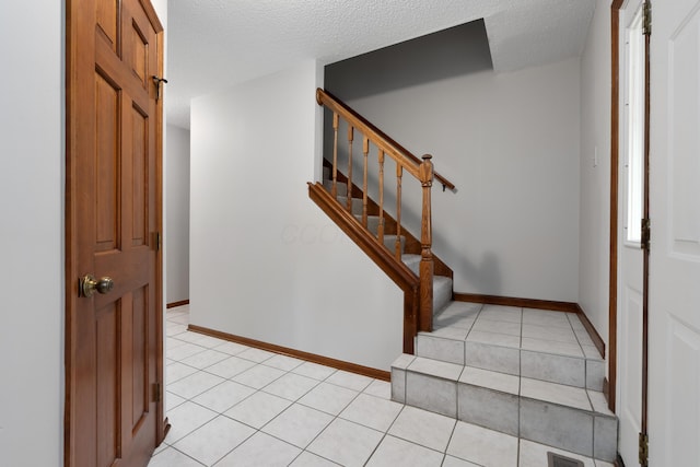 2321 Worthingwoods Blvd, Powell, OH 43065 - entryway with light tile patterned floors, stairs, a textured ceiling, and baseboards