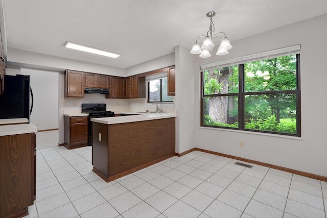 2321 Worthingwoods Blvd, Powell, OH 43065 - kitchen featuring black appliances, under cabinet range hood, a sink, light countertops, and a peninsula