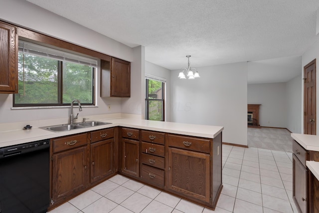 2321 Worthingwoods Blvd, Powell, OH 43065 - kitchen with black dishwasher, a sink, a peninsula, light countertops, and a chandelier