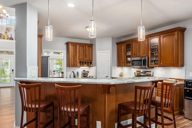 5552 Quail Hollow Way, Westerville, OH 43082 - kitchen with stainless steel appliances, wood finished floors, brown cabinetry, plenty of natural light, and recessed lighting