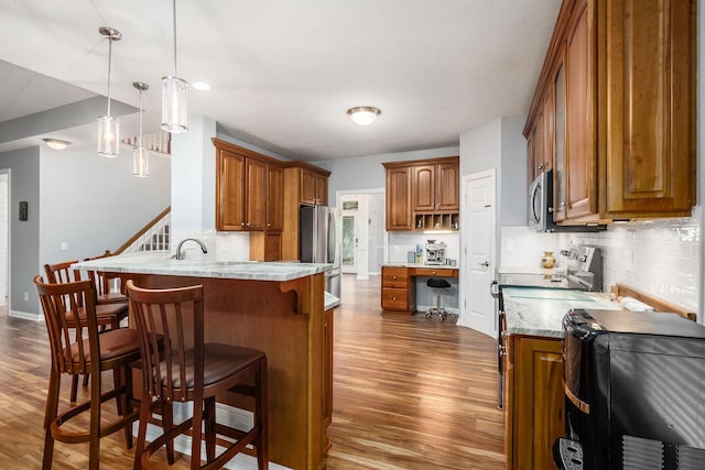 5552 Quail Hollow Way, Westerville, OH 43082 - kitchen with a peninsula, stainless steel appliances, brown cabinetry, and dark wood-style floors