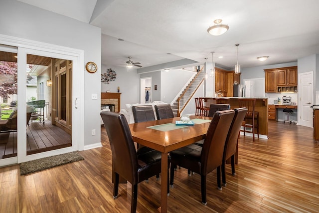 5552 Quail Hollow Way, Westerville, OH 43082 - dining area featuring stairway, dark wood-style flooring, baseboards, and a stone fireplace