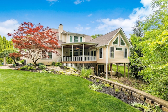 5552 Quail Hollow Way, Westerville, OH 43082 - rear view of property featuring a ceiling fan, a chimney, a lawn, a sunroom, and roof with shingles