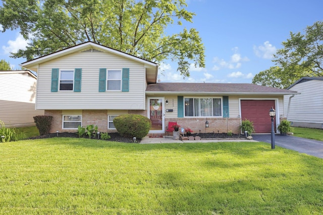 5042 Lindora Dr, Columbus, OH 43232 - tri-level home with driveway, an attached garage, a front lawn, and brick siding