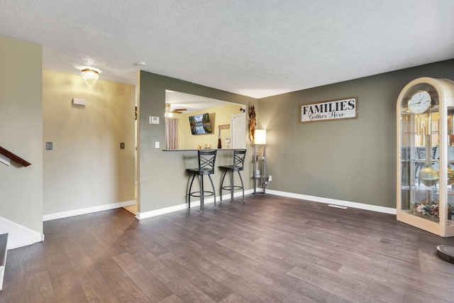 5042 Lindora Dr, Columbus, OH 43232 - living area with wood finished floors, a textured ceiling, baseboards, a bar, and ceiling fan
