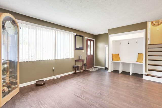 5042 Lindora Dr, Columbus, OH 43232 - unfurnished living room featuring dark wood-style floors, baseboards, a textured ceiling, and stairs