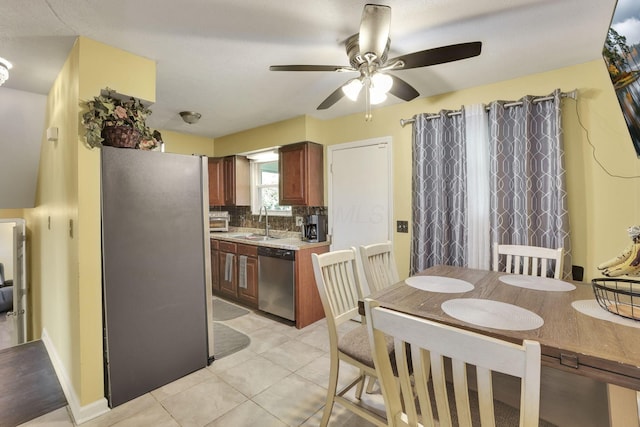 5042 Lindora Dr, Columbus, OH 43232 - kitchen featuring stainless steel appliances, a sink, a ceiling fan, decorative backsplash, and light countertops