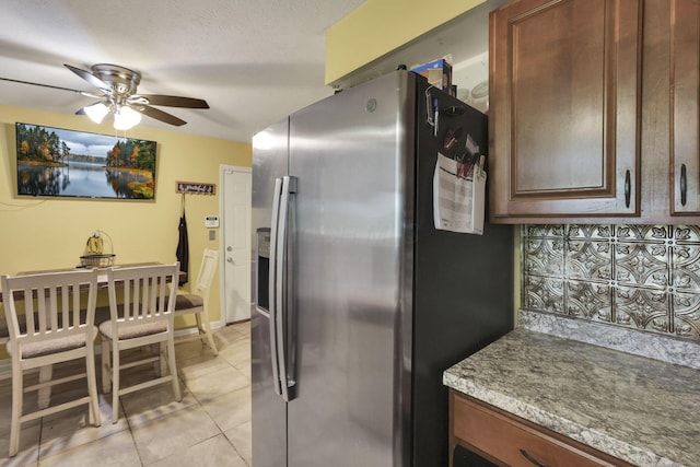 5042 Lindora Dr, Columbus, OH 43232 - kitchen featuring stainless steel refrigerator with ice dispenser, ceiling fan, light tile patterned floors, backsplash, and light stone countertops