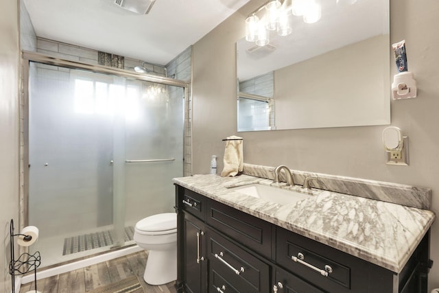 5042 Lindora Dr, Columbus, OH 43232 - bathroom with toilet, vanity, wood finished floors, and a stall shower