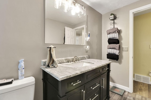 5042 Lindora Dr, Columbus, OH 43232 - bathroom with vanity, toilet, wood finished floors, and baseboards