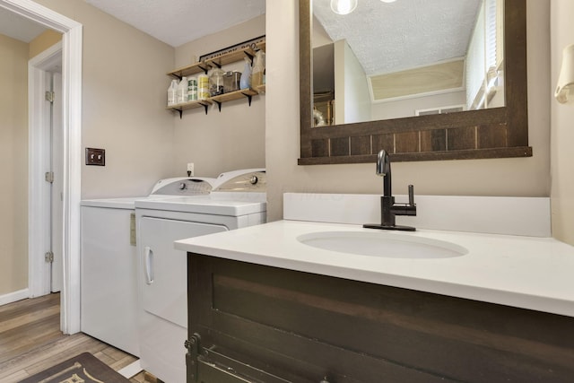 5042 Lindora Dr, Columbus, OH 43232 - bathroom featuring washer and dryer, wood finished floors, a textured ceiling, and vanity