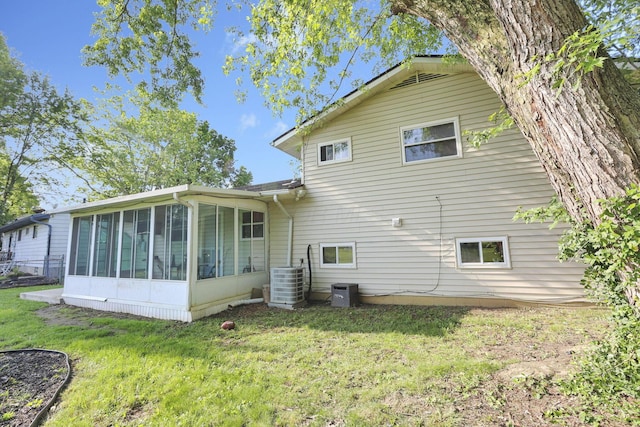 5042 Lindora Dr, Columbus, OH 43232 - back of property with a sunroom, cooling unit, and a lawn