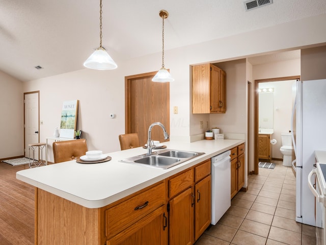 2594 Roberts Ct, Hilliard, OH 43026 - kitchen with a sink, white appliances, light countertops, a peninsula, and pendant lighting