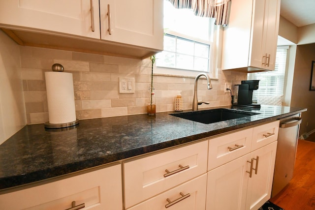 6736 Worthington Galena Rd, Worthington, OH 43085 - kitchen with a sink, stainless steel dishwasher, white cabinetry, backsplash, and dark stone countertops