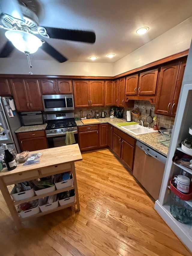 688 S 5th St, Columbus, OH 43206 - kitchen featuring appliances with stainless steel finishes, a sink, light wood-style floors, and decorative backsplash