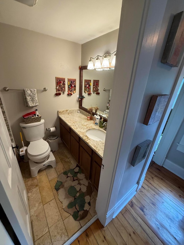 688 S 5th St, Columbus, OH 43206 - bathroom featuring double vanity, toilet, and wood finished floors