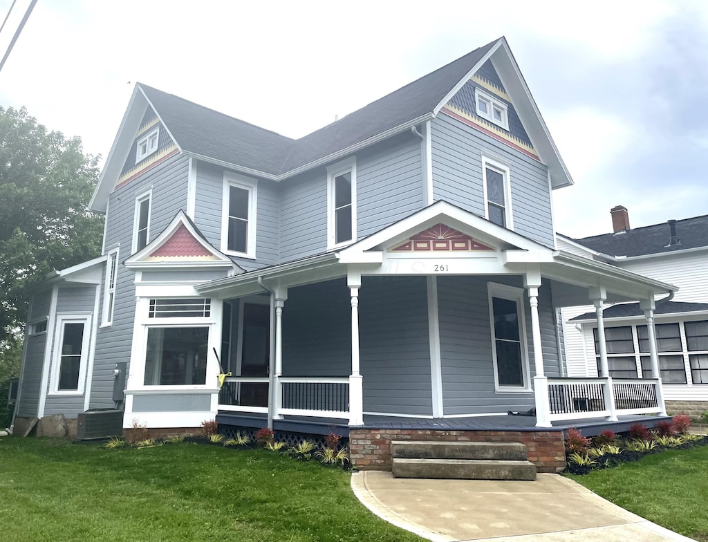 261 W 6th St, Marysville, OH 43040 - victorian home featuring covered porch, a front lawn, and central AC