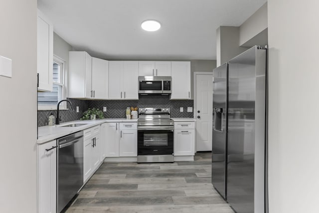 338 Gentlewind Dr, Westerville, OH 43081 - kitchen with appliances with stainless steel finishes, a sink, light countertops, white cabinetry, and light wood-style floors