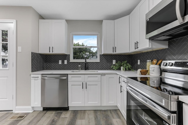 338 Gentlewind Dr, Westerville, OH 43081 - kitchen with appliances with stainless steel finishes, a sink, light wood-style flooring, and light countertops