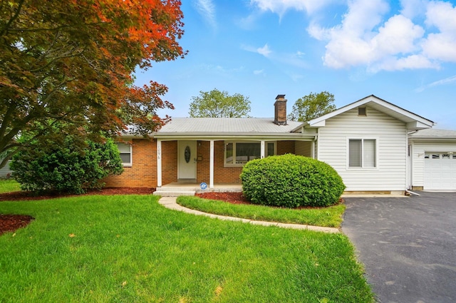 1096 Lancaster Ave, Reynoldsburg, OH 43068 - ranch-style home featuring asphalt driveway, covered porch, a chimney, a front lawn, and brick siding