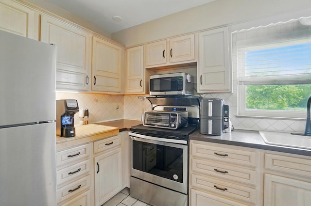 1096 Lancaster Ave, Reynoldsburg, OH 43068 - kitchen featuring stainless steel appliances, a sink, tasteful backsplash, and light tile patterned floors