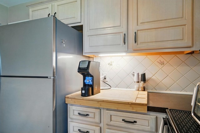 1096 Lancaster Ave, Reynoldsburg, OH 43068 - kitchen with freestanding refrigerator, backsplash, and cream cabinets