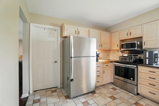 1096 Lancaster Ave, Reynoldsburg, OH 43068 - kitchen with appliances with stainless steel finishes, decorative backsplash, and light brown cabinets